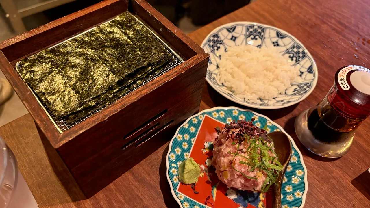 A box of nori sheets, a bowl of rice and a mound of chopped fatty tuna with pickled daikon