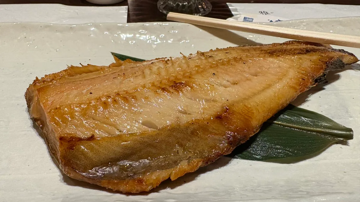 A large split grilled hokke (Atka mackerel) on a rectangular plate at an izakaya