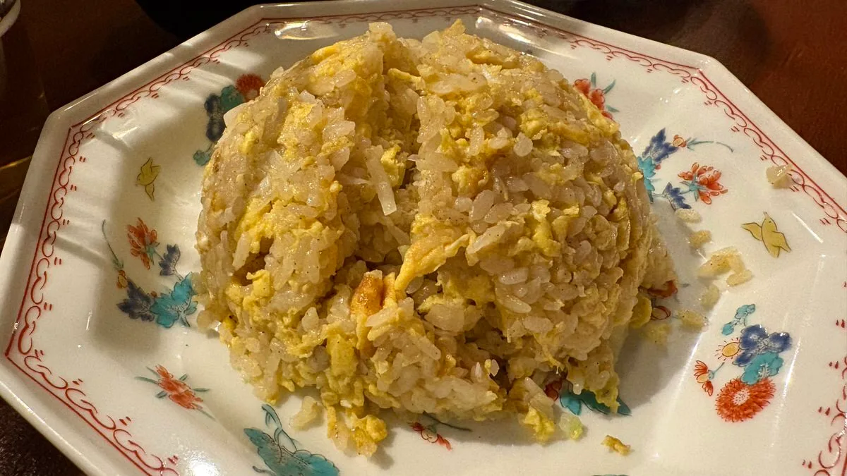 A plate of egg fried rice on a wooden table at the beer bar